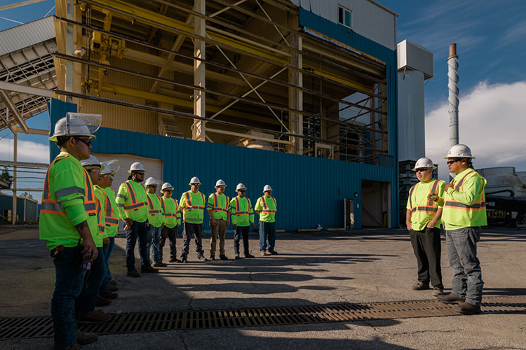 Construction workers standing in outdoor meeting wearing safety vests